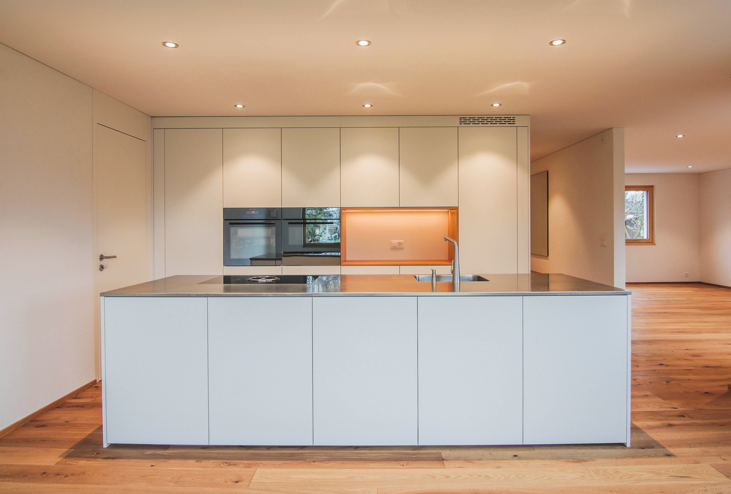 sehr moderne, weiß graue Küche, frontal fotografiert